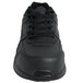 A close-up of a Genuine Grip black leather athletic shoe with laces.