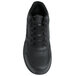 A close-up of a Genuine Grip black leather athletic shoe with black laces.