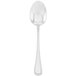 A silver Walco Accolade serving spoon with a white handle on a white background.