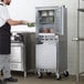 A man in a black apron standing in a school kitchen with a Beverage-Air UCR20HC undercounter refrigerator.