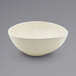 A white Front of the House Kiln oval tall porcelain bowl on a gray surface.