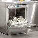 A Hobart LXeH-5 undercounter dishwasher with dishes inside and the shelf open.