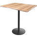 A Holland Bar Stool EnduroTop table with a natural wood top and black round base.