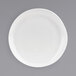 A close up of a Front of the House Kiln Superwhite porcelain plate with a small rim on a gray surface.
