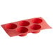 A red silicone muffin pan with five compartments.