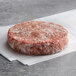 A raw Warrington Farm Meats burger patty on a white background.