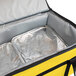 A yellow and black Sterno large insulated food carrier with a silver tray inside.