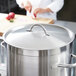 A Vollrath stainless steel domed cover on a large pot.