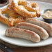 A plate with Warrington Farm Meats Weisswurst Sausages and pretzels.