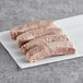 Warrington Farm Meats Bratwurst Sausage links on a white paper.