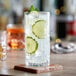 A close-up of an Acopa highball glass filled with water, lime, and mint.