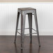A Flash Furniture distressed silver metal bar height stool with a drain hole seat.
