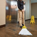 A woman holding a Rubbermaid disposable wet mop and using it to clean a floor.