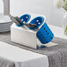 A Steril-Sil stainless steel flatware organizer with blue perforated plastic cylinders holding silverware.