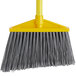 A Rubbermaid grey angle broom with a metal handle.