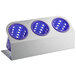 A white rectangular container with blue holes holding three purple cylinders.