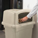A hand opening a Continental Colossus outdoor trash can with two doors.