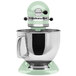 A KitchenAid Artisan Series mixer with a green top over a bowl.