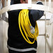 A man holding a DuroMax yellow triple tap extension power cord.