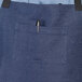 A blue Uncommon Chef denim apron with black webbing and a pocket.