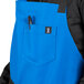 A person wearing a blue Uncommon Chef bib apron with black webbing and pockets.