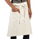 A person wearing a sand beige Moxie waist apron with natural webbing.