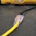 A yellow DuroMax extension cord plugged into a yellow cord.