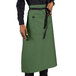 A person wearing a sea green Uncommon Chef bistro apron with black webbing.