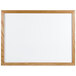 An Aarco oak-framed white marker board.