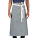 A person wearing a grey Uncommon Chef bistro apron with natural webbing.