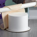 A white Baker's Mark foam round cake dummy on a table.
