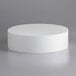 A white cylinder on a gray surface with Baker's Mark 14" x 4" Foam Round Cake Dummy.