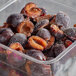 A plastic container of 22 lb. IQF halved plums.