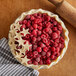A pie with raspberries and stars on top.
