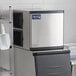 An Avantco air cooled full cube ice machine in a kitchen with a white scoop.