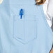 A person wearing a sky blue Uncommon Chef bib apron.