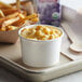 A tray with a Choice white paper food cup of macaroni and cheese and fries.