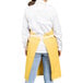 A woman wearing a yellow Uncommon Chef apron.