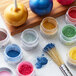 A jar of Roxy & Rich Black Sparkle Dust on a table with jars of colorful powders and a brush.