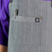 A man wearing a Uncommon Chef denim apron with black webbing and pockets.