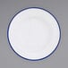 A close-up of a Crow Canyon Home white enamelware plate with a blue rim.