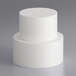 A stack of white cylindrical cake dummies.