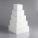 A stack of white square cake dummies with a corner in focus.