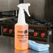 A 32 oz. labeled bottle of Noble Chemical Orange Peel Citrus Solvent Cleaner on a countertop.