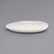 A close up of a white Front of the House Tides scallop oval porcelain plate.