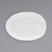 A white oval porcelain plate with a small oval shape on it.