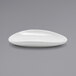 A Front of the House Tides white oval porcelain saucer on a gray surface.