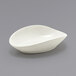 A Front of the House Tides semi-matte scallop oval porcelain ramekin on a gray surface.