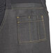 The back of a person wearing a black denim apron with black webbing.