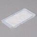 A white rectangular absorbent meat pad on a gray surface.
